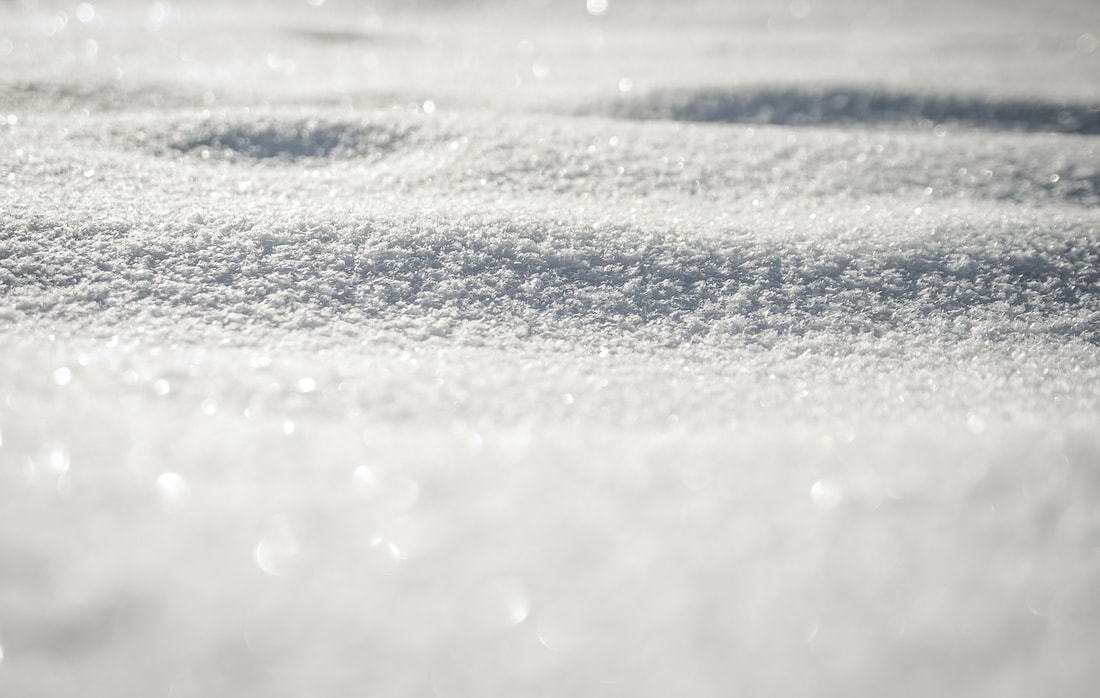 A close-up of icy white powdery snow laying on the ground